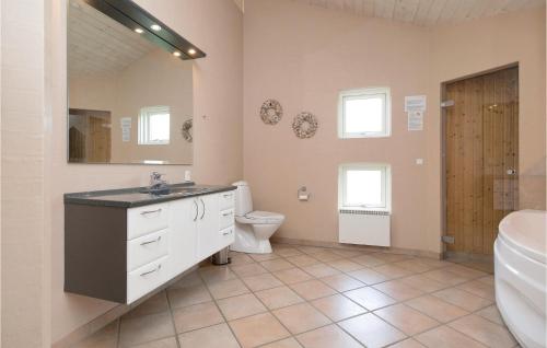 a bathroom with a sink and a toilet and a tub at Stunning Home In Lkken With 5 Bedrooms, Sauna And Wifi in Løkken