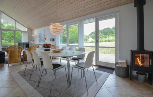 a dining room with a table and chairs and a fireplace at Holiday Home Nordbakken Ebeltoft Vi in Ebeltoft