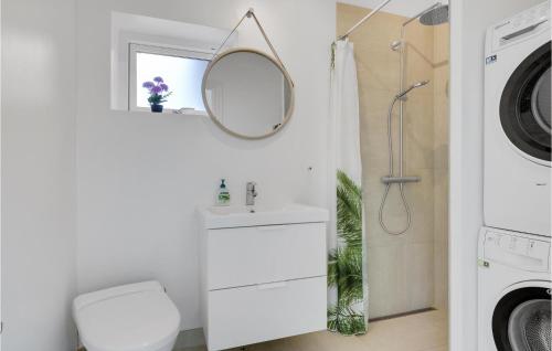 a bathroom with a sink and a mirror and a washing machine at Stunning Home In Rdby With Outdoor Swimming Pool in Rødby