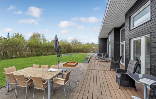 eine Terrasse mit Tisch und Stühlen und einem Sonnenschirm in der Unterkunft Amazing Home In Hemmet With Sauna in Hemmet