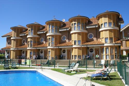 a large building with a pool in front of it at Apartamentos Quinto Sueño in Noja