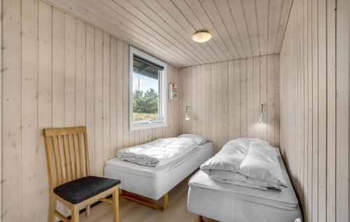 Sønderhoにある4 Bedroom Amazing Home In Fanのベッド2台、椅子、窓が備わる客室です。
