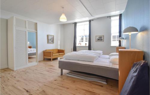 ein Schlafzimmer mit einem großen Bett in einem Zimmer mit Fenstern in der Unterkunft Det Gamle Gasvrk in Bogense