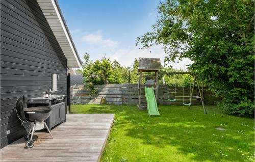 a backyard with a wooden deck and a playground at Four-Bedroom Holiday Home In Odder in Odder
