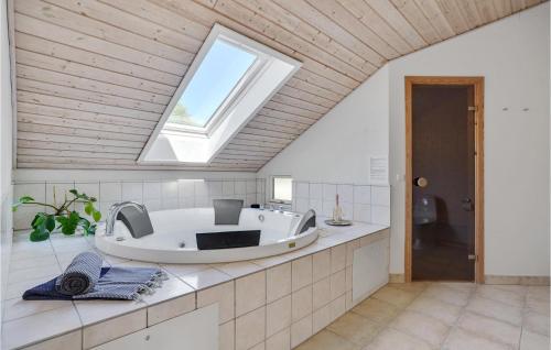 Bøtø ByにあるBeautiful Home In Idestrup With 4 Bedrooms, Sauna And Wifiのバスルーム(バスタブ付)、窓が備わります。