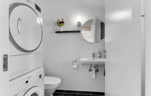 a white bathroom with a sink and a mirror at Awesome Home In Haderslev With 3 Bedrooms, Wifi And Sauna in Flovt