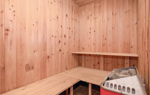 a wooden sauna with a bench and a stove at Awesome Home In Hadsund With Sauna in Haslevgårde