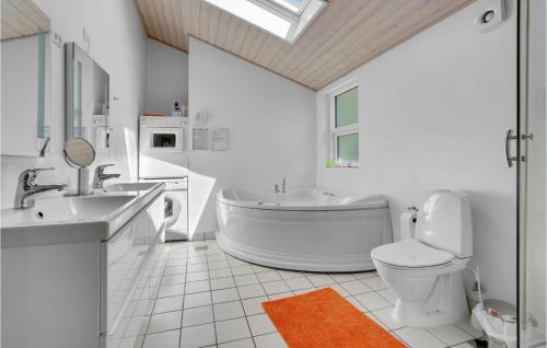 a bathroom with a tub and a toilet and a sink at Stunning Home In Juelsminde With Wifi in Sønderby
