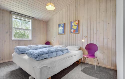 a bedroom with a bed and a purple chair at Stunning Home In Juelsminde With Wifi in Sønderby
