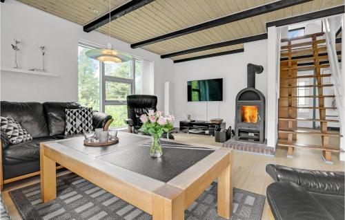 a living room with a table and a fireplace at Holiday Home Romo Lxviii in Bolilmark