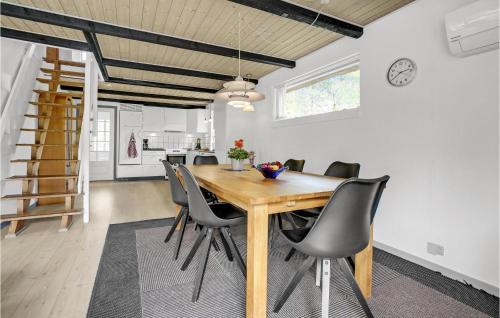 a dining room with a wooden table and chairs at Holiday Home Romo Lxviii in Bolilmark