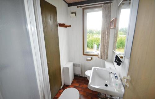 a bathroom with a sink and a toilet and a window at 3 Bedroom Beautiful Home In Glesborg in Bønnerup Strand