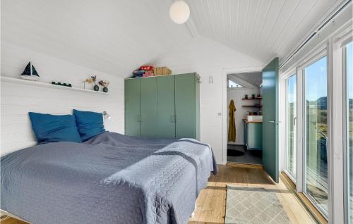 a bedroom with a bed with blue pillows at Stunning Home In Fan With Kitchen in Fanø