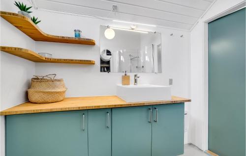 a bathroom with blue cabinets and a sink at Stunning Home In Fan With Kitchen in Fanø