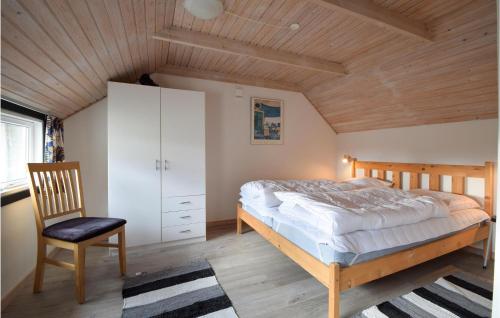 1 dormitorio con 1 cama y 1 silla en 3 Bedroom Awesome Home In Brenderup Fyn, en Skovs-Højrup