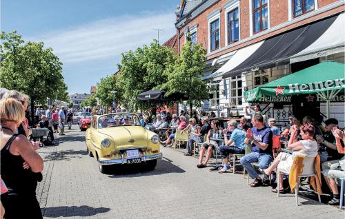 an old car driving down a street with a crowd of people at Apartment Havnevej Nykøbing Sj Iii in Nykøbing Sjælland