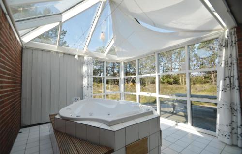 un ampio bagno con vasca in una stanza con finestre di Holiday Home Jtagholmsvej Rømø I a Rømø Kirkeby