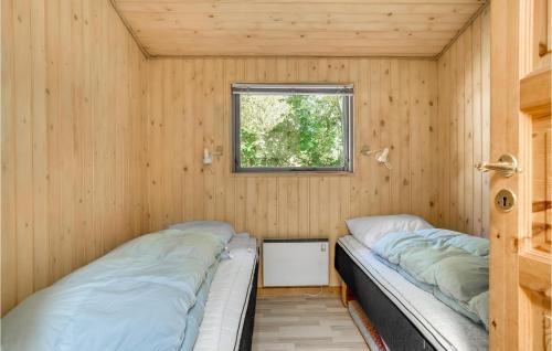 two beds in a small room with a window at Amazing Home In Humble With Sauna in Humble
