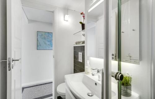 W białej łazience znajduje się umywalka i lustro. w obiekcie Feriecenter Klinten w mieście Fåborg
