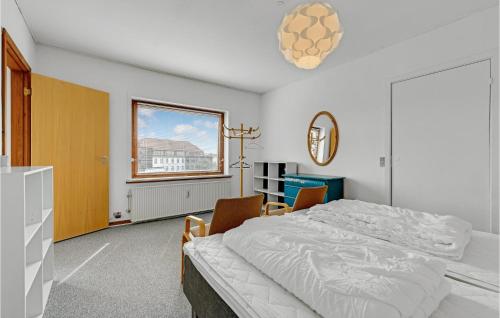 ein weißes Schlafzimmer mit einem Bett und einem Fenster in der Unterkunft Beautiful Apartment In Aabenraa With House A Panoramic View in Aabenraa