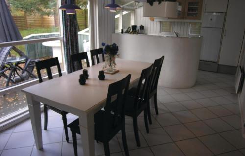a dining room with a table and chairs in a kitchen at Holiday Home Bl in Dronningmølle