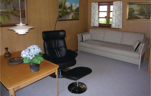 a living room with a black chair and a table at Annekset in Bagenkop
