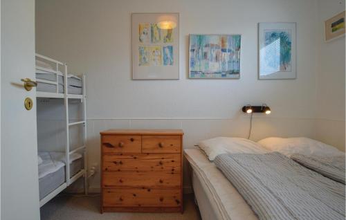 a bedroom with a bed and a wooden dresser at Terrassehus in Fæbæk