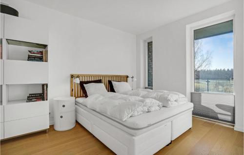 een witte slaapkamer met een bed en een raam bij Gorgeous Apartment In Nimtofte With Wifi in Nimtofte
