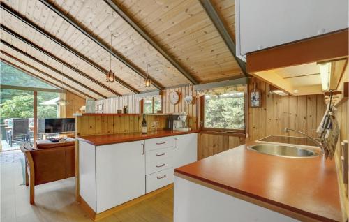 uma cozinha com armários brancos e um tecto de madeira em Lovely Home In Hjby With Wifi em Højby