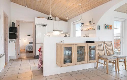 eine Küche mit weißen Wänden und Holzschränken in der Unterkunft Three-Bedroom Holiday Home In Harboore in Harboør