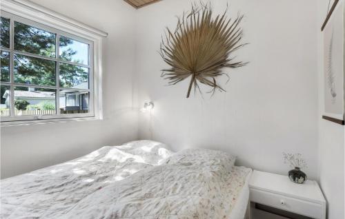 a white bedroom with a bed and a window at Holiday Home Midtvej Nexø Iv in Balke