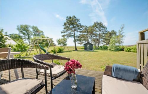 a table with flowers on a deck with a playground at Holiday Home Flejmose Sydals Vi in Kegnæshøj