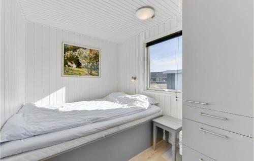 BjerregårdにあるNice Home In Hvide Sande With Saunaの白いベッドルーム(ベッド1台、窓付)