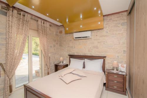 a bedroom with a bed and a large window at Cretan Nature Villa Alexandra in Zarós
