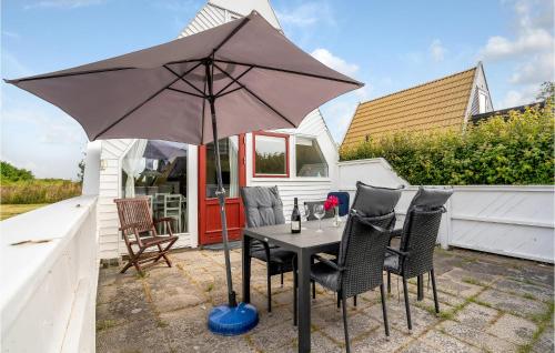 a table and chairs with an umbrella on a patio at Holiday Home Gedser Feriepark Gedser Vi in Gedser