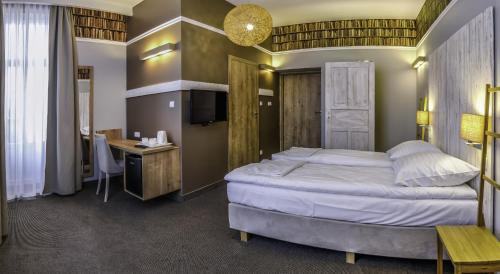 a bedroom with a large bed and a desk at Willa Sudety in Kudowa-Zdrój