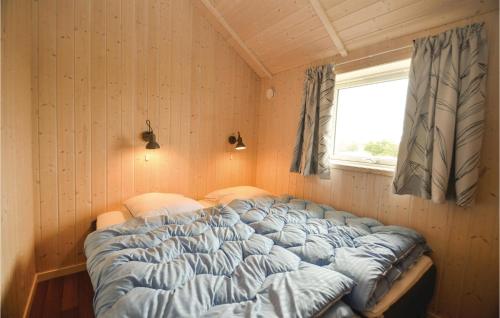 a bed in a corner of a room with a window at 3 Bedroom Lovely Home In Vggerlse in Marielyst