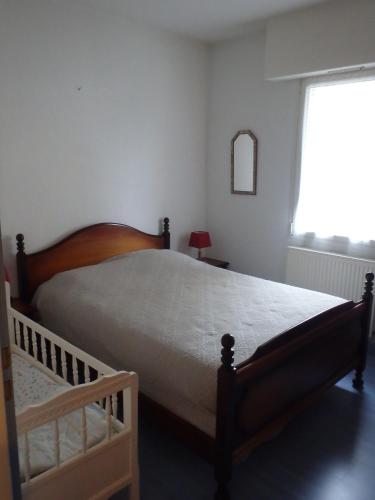 une chambre avec un grand lit et une fenêtre dans l'établissement Le Moulin des Prés avec terrasse, à Vesoul