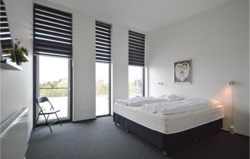 1 dormitorio con 1 cama, 1 silla y ventanas en Stunning Apartment In Rm With Wifi, en Havneby