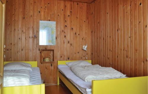 - une chambre avec 2 lits dans un mur en bois dans l'établissement Karin, à Fanø
