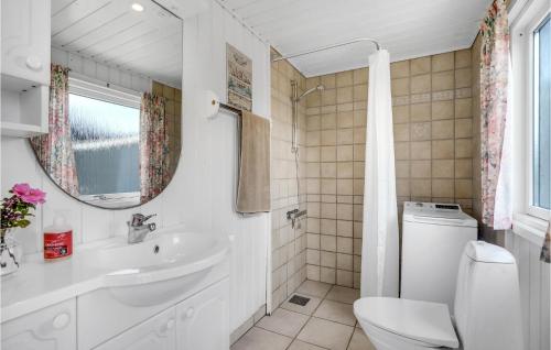 een badkamer met een wastafel, een toilet en een spiegel bij 3 Bedroom Gorgeous Home In Fan in Sønderho