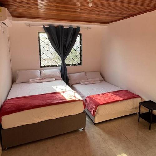 two beds in a room with a window at Casa Salmón Confortable Casa Completa in Valledupar