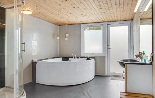 y baño con lavabo y bañera blanca grande. en Nice Home In Nrre Nebel With Sauna, en Nymindegab