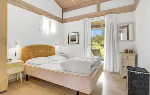 Un dormitorio con una cama grande y una ventana en Nice Home In Nrre Nebel With Sauna, en Nymindegab