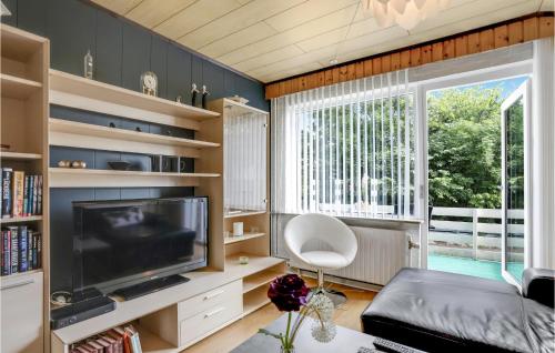 a living room with a large television and a window at 1 Bedroom Cozy Apartment In Allinge in Allinge