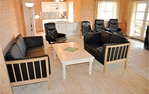 a living room with couches and a table and chairs at Holiday Home Sydals 16 With Hot Tub in Skovby