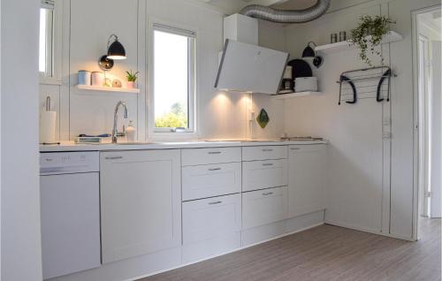 een witte keuken met witte kasten en een raam bij Beautiful Home In Grsted With Wifi in Udsholt Sand