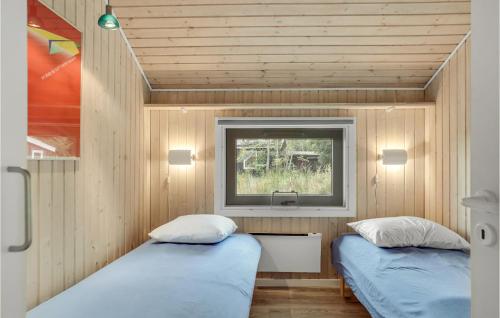 two beds in a small room with a window at Awesome Home In Hadsund With Sauna in Hadsund