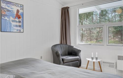 a bedroom with a chair and a bed and a window at Imagine in Bedegård
