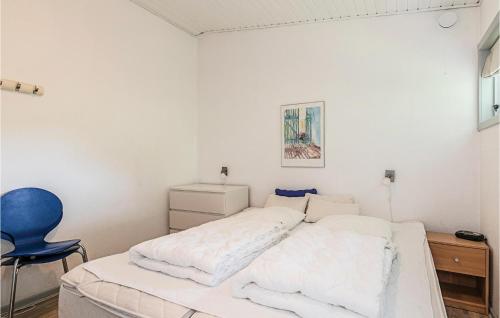 Strandby Gårdeにある1 Bedroom Lovely Apartment In Nexの白いベッドルーム(ベッド1台、青い椅子付)